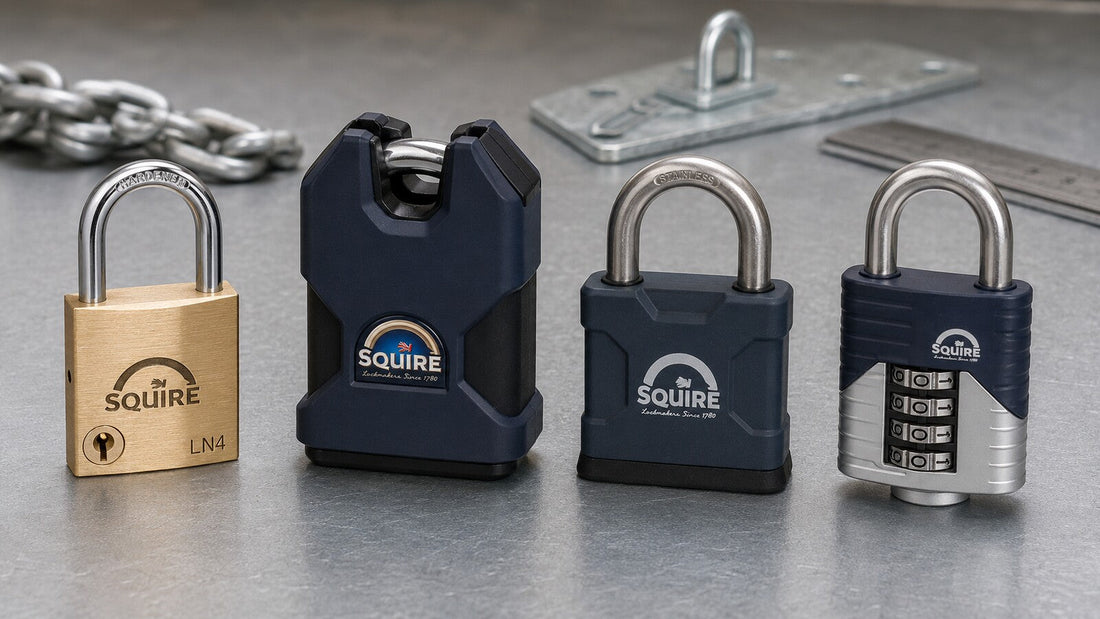 Four different Squire padlocks on a metal workbench, including brass, closed-shackle, weather-resistant and four-wheel combination designs.